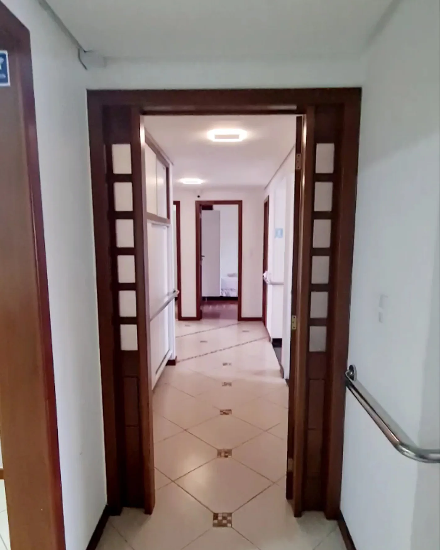 Corredor da LARES, limpo, com corrimão ao longo da parede