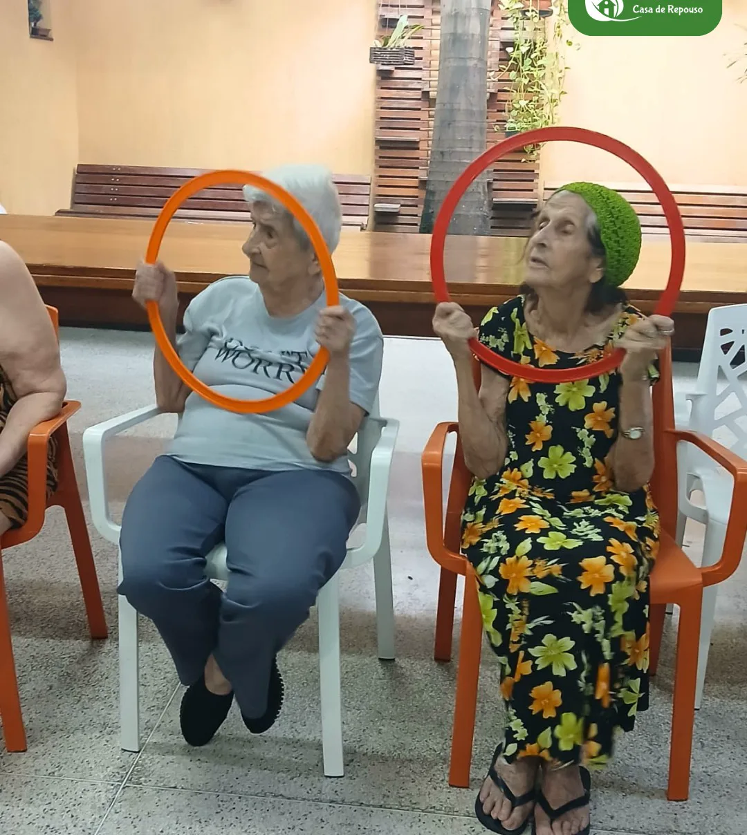 Moradoras da LARES em roda numa atividade com bambolês
