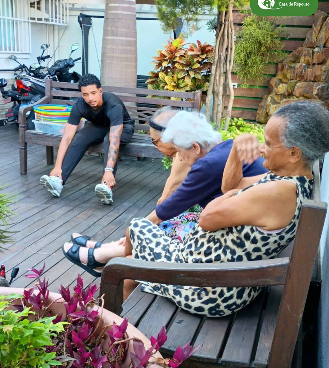 Educador físico orientando moradoras da LARES em exercício no deck